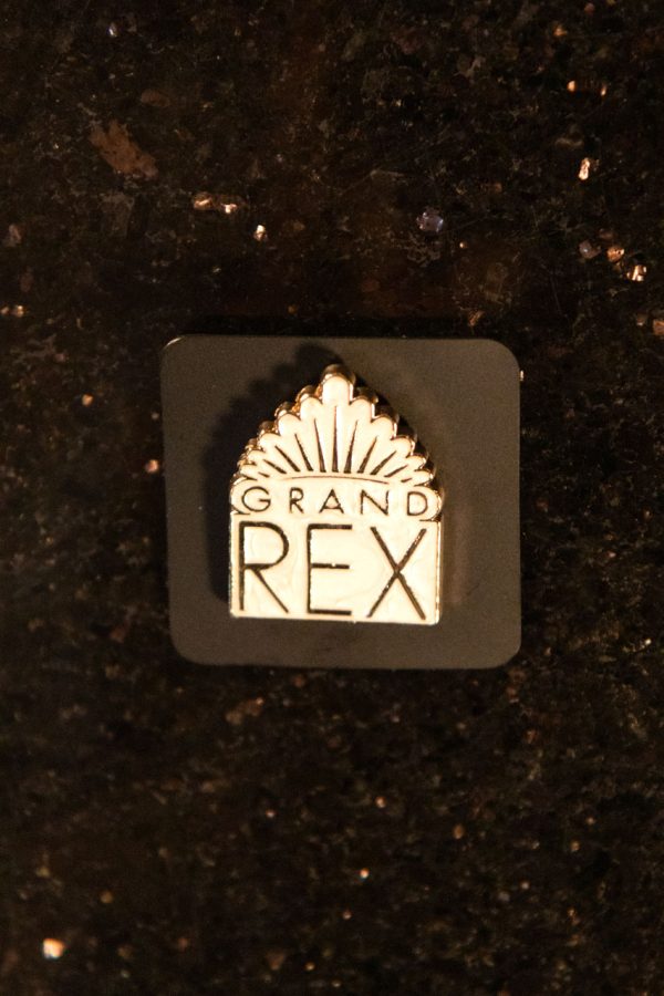 Pin's "Grand Rex" blanc, souvenir dérivé vendu par la boutique du cinéma Le Grand Rex